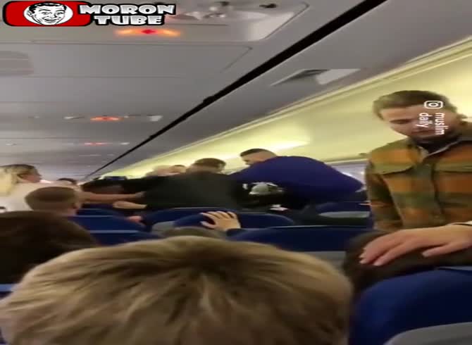 Video :Three guys on an aircraft attack a man who is accused of racism